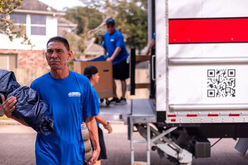 Mover carrying moving blankets from the truck in Sugar Land