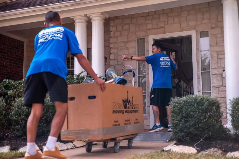 Movers carrying boxes into a Sugar Land home