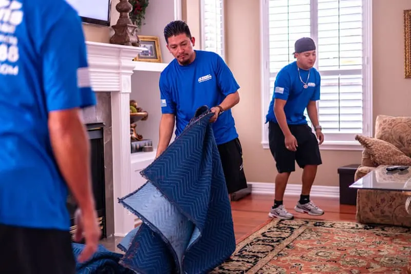 Movers laying out moving blankets in a Sugar Land living room