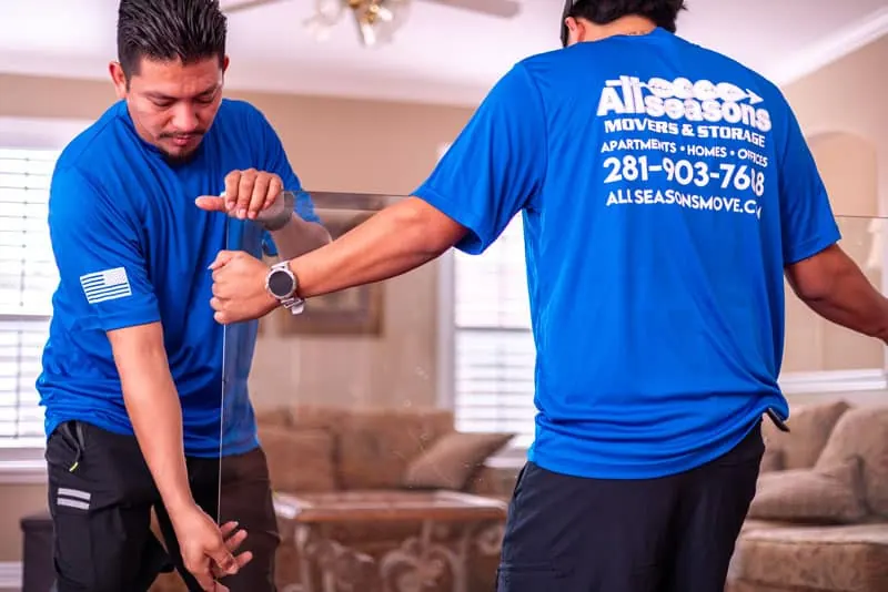 Movers stretch wrapping furniture in a Sugar Land living room