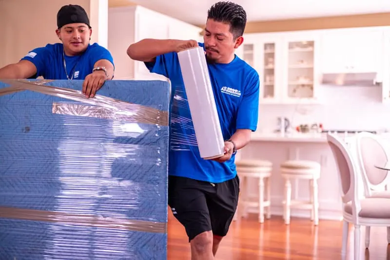 Movers wrapping a mattress in plastic in Sugar Land, TX