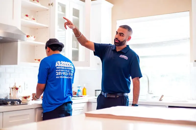 Movers planning a kitchen pack in a Sugar Land home